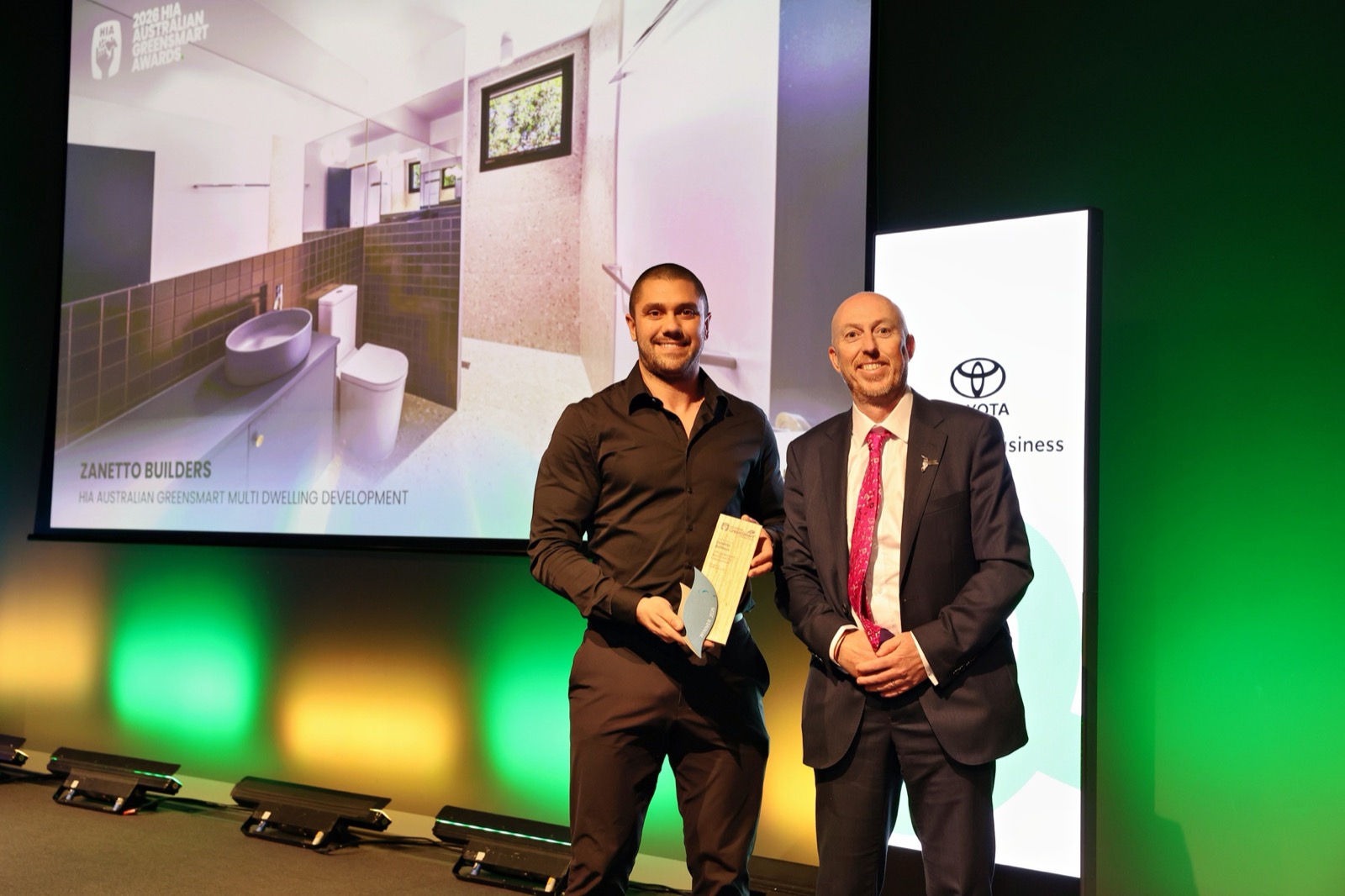 Zanetto Builders receiving the HIA Australian GreenSmart Multi Dwelling Development award 2026 on stage in Melbourne