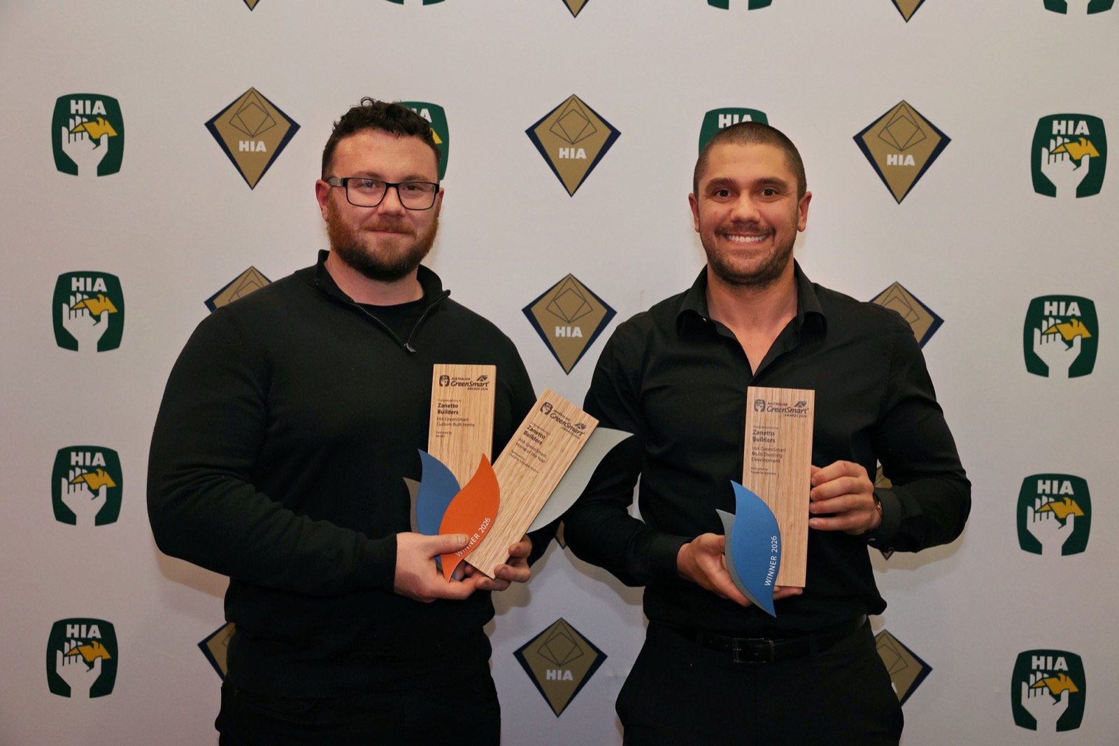 Zanetto Builders holding three 2026 HIA Australian GreenSmart Awards trophies — Home of the Year, Custom Built Home and Multi Dwelling Development